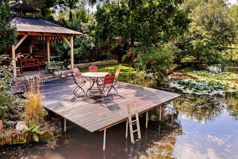 Idyllischer Garten mit Holzsteg und Schwimmteich – Außenaufnahme für ein Immobilienexposé im Landkreis Potsdam-Mittelmark